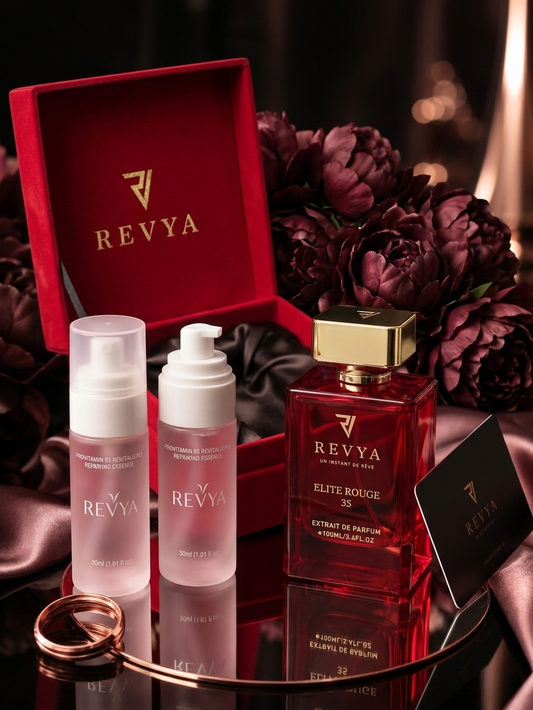 Revya perfume set with bottles and a box on a reflective surface with flowers in the background.